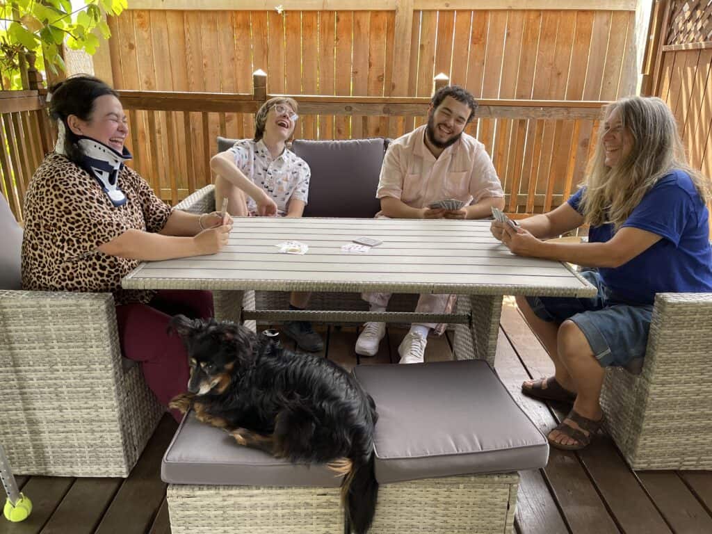 four people sitting around a table and laughing